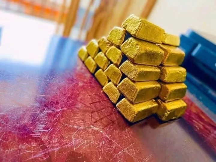 Gold bars stacked in a pyramid on a table